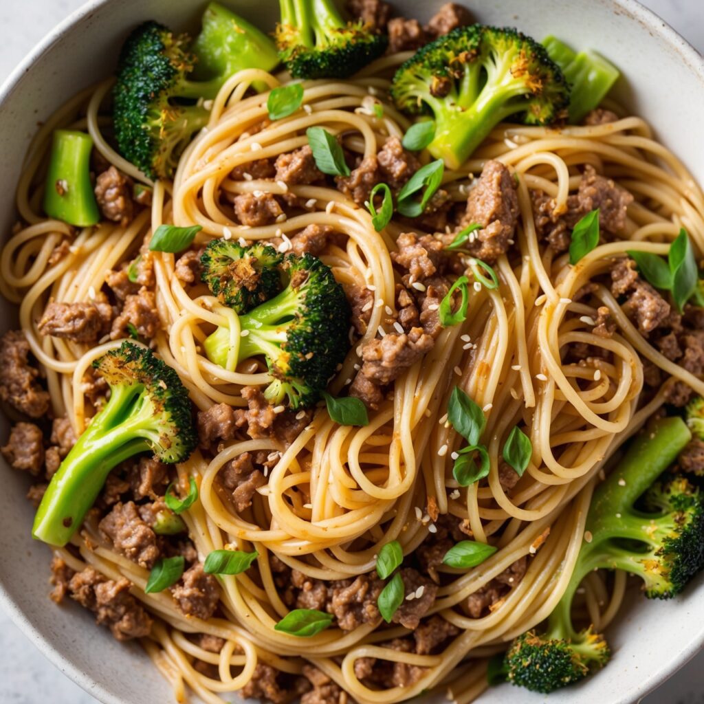 A plate of Beef and Broccoli Noodles with tender beef strips, crisp broccoli, and noodles coated in a savory sauce.